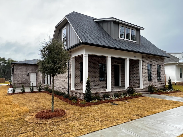 view of front of house with covered porch and a front lawn