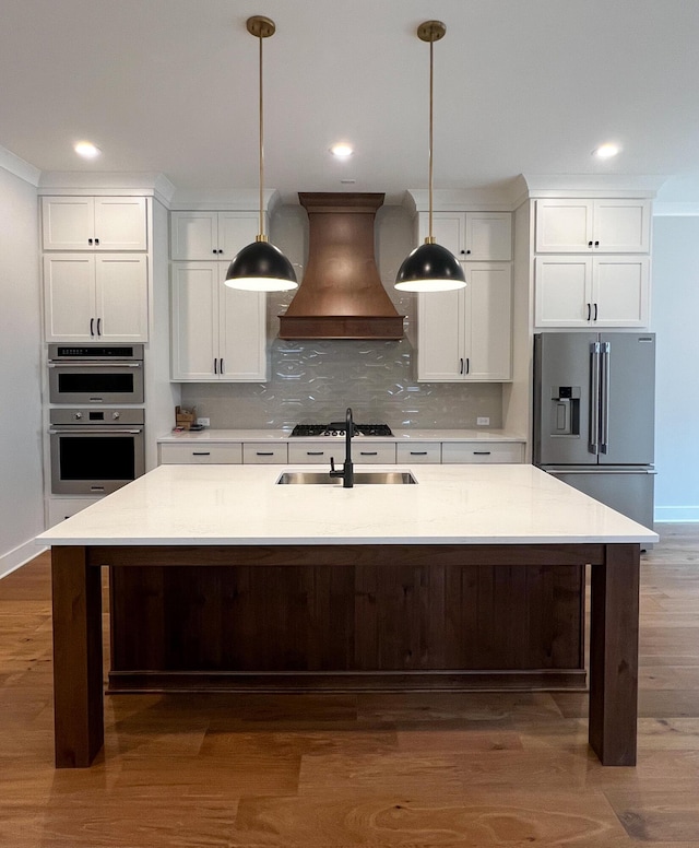 kitchen with white cabinetry, appliances with stainless steel finishes, custom range hood, and hanging light fixtures