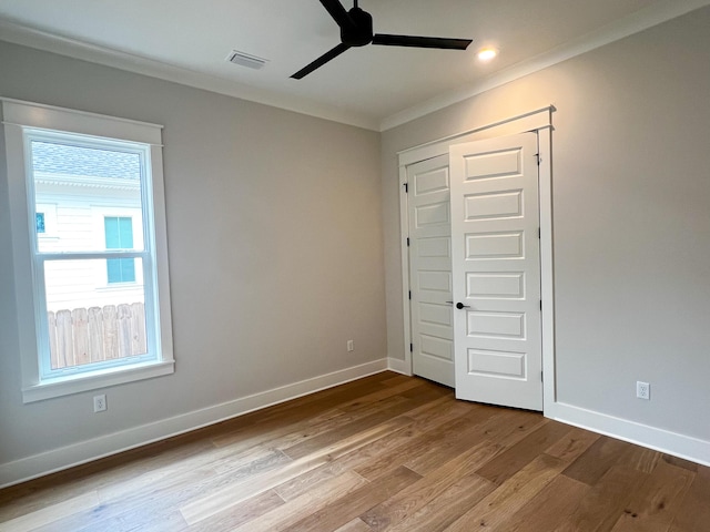 unfurnished bedroom with ceiling fan, light wood-type flooring, a closet, and crown molding