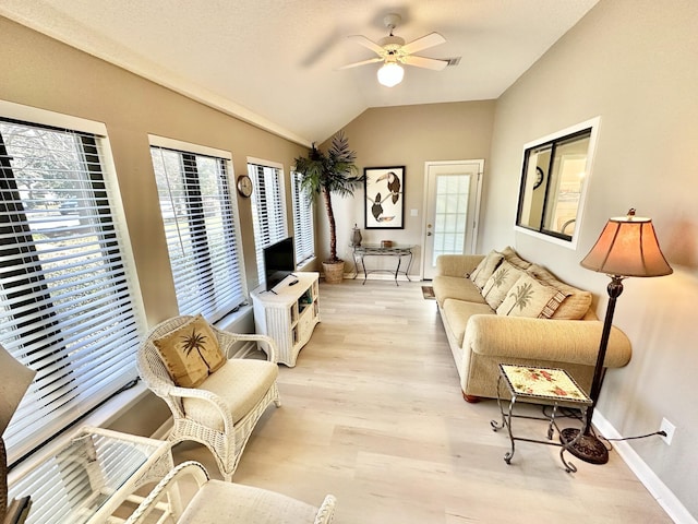 living room with ceiling fan, light hardwood / wood-style flooring, and vaulted ceiling