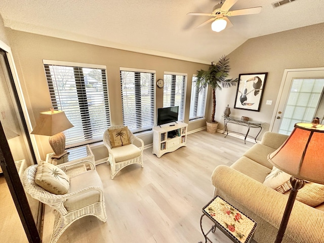 living room featuring ceiling fan, wood-type flooring, a wealth of natural light, and vaulted ceiling