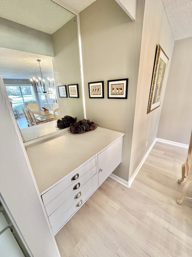 interior details featuring a notable chandelier, a textured ceiling, and hardwood / wood-style flooring