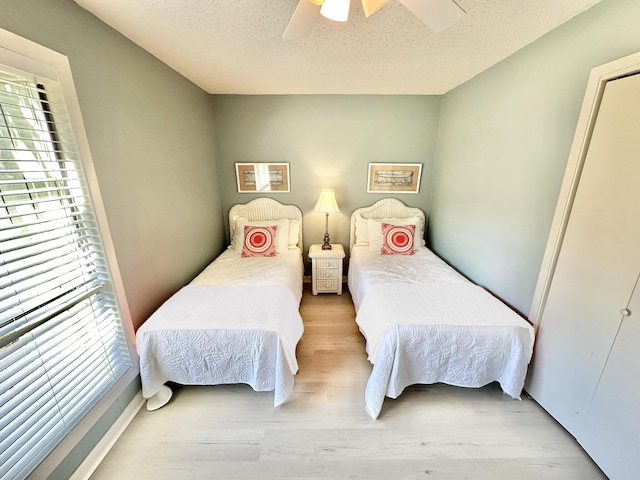 bedroom with ceiling fan, multiple windows, and a textured ceiling