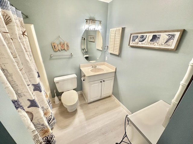 bathroom with toilet, vanity, a shower with curtain, and hardwood / wood-style floors