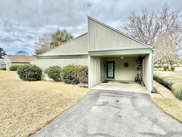 view of side of home with a lawn and a carport