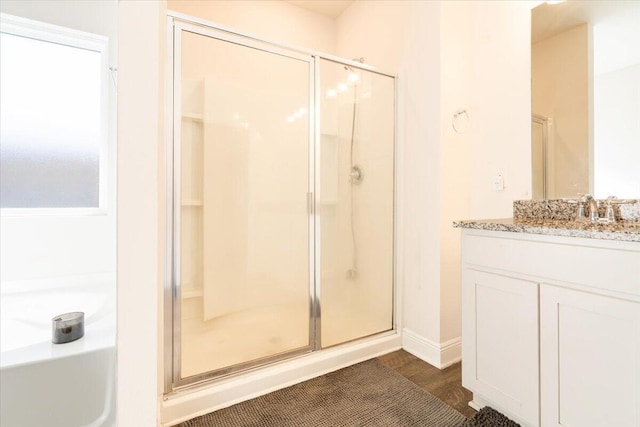 bathroom with vanity, a shower with door, and hardwood / wood-style floors