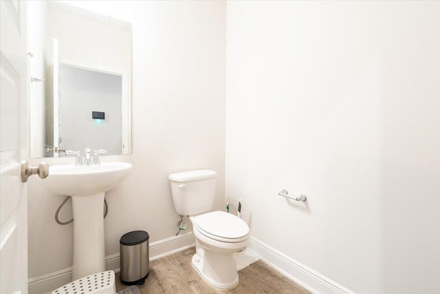 bathroom with sink, hardwood / wood-style flooring, and toilet