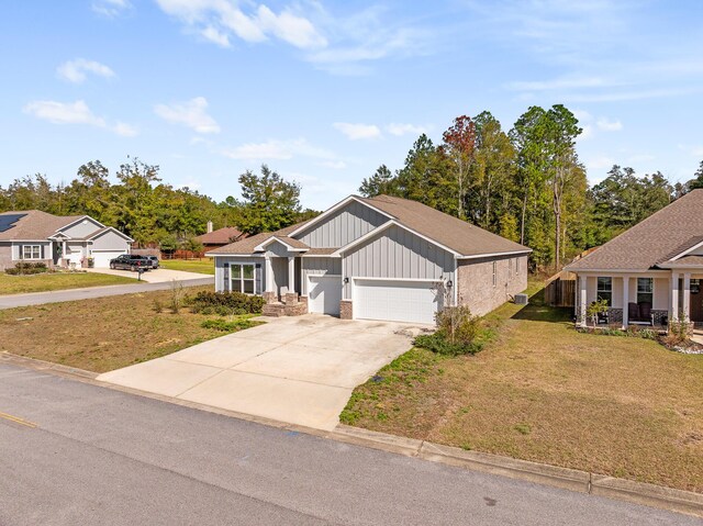 8177 Majestic Cypress Dr, Milton, FL 32583 - craftsman inspired home featuring a front lawn, driveway, an attached garage, and board and batten siding