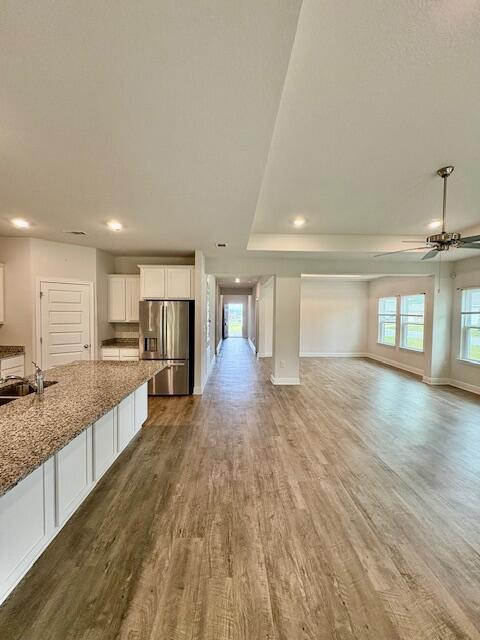 8177 Majestic Cypress Dr, Milton, FL 32583 - kitchen with open floor plan, stainless steel refrigerator with ice dispenser, dark wood-style flooring, a sink, and white cabinets