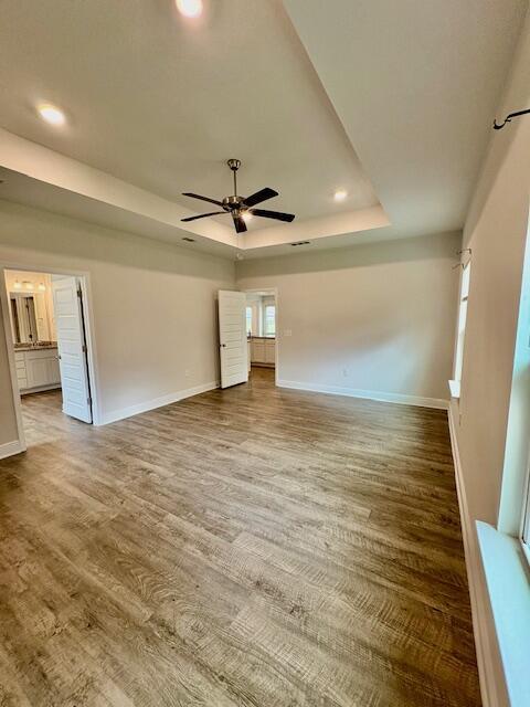 8177 Majestic Cypress Dr, Milton, FL 32583 - unfurnished room featuring a tray ceiling, a ceiling fan, wood finished floors, baseboards, and recessed lighting