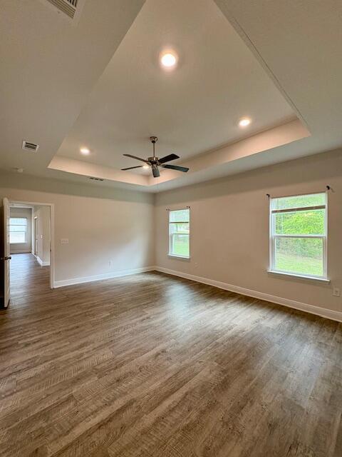 8177 Majestic Cypress Dr, Milton, FL 32583 - spare room with dark wood-style floors, a tray ceiling, and ceiling fan