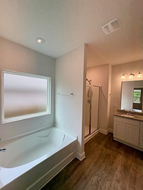 8177 Majestic Cypress Dr, Milton, FL 32583 - full bathroom featuring a stall shower, vanity, a garden tub, wood finished floors, and visible vents