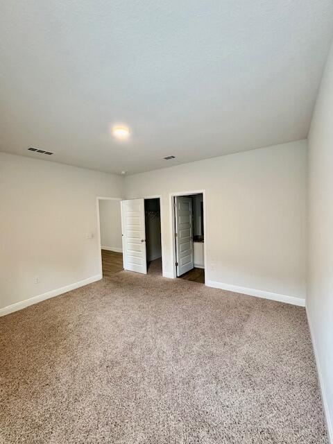 8177 Majestic Cypress Dr, Milton, FL 32583 - empty room with baseboards, dark colored carpet, and visible vents