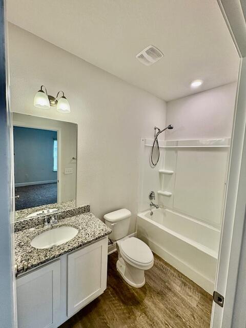 8177 Majestic Cypress Dr, Milton, FL 32583 - full bath with visible vents, toilet, wood finished floors, vanity, and shower / tub combination