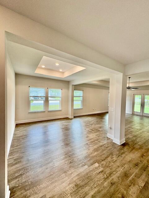 8177 Majestic Cypress Dr, Milton, FL 32583 - spare room featuring plenty of natural light, baseboards, wood finished floors, and a raised ceiling