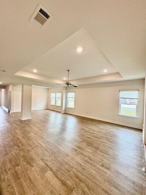 8177 Majestic Cypress Dr, Milton, FL 32583 - unfurnished room featuring visible vents, wood finished floors, and a raised ceiling