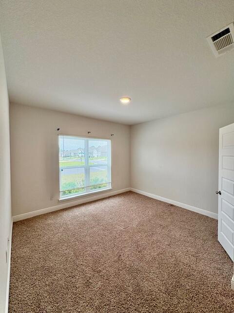 8177 Majestic Cypress Dr, Milton, FL 32583 - carpeted empty room with a textured ceiling, baseboards, and visible vents
