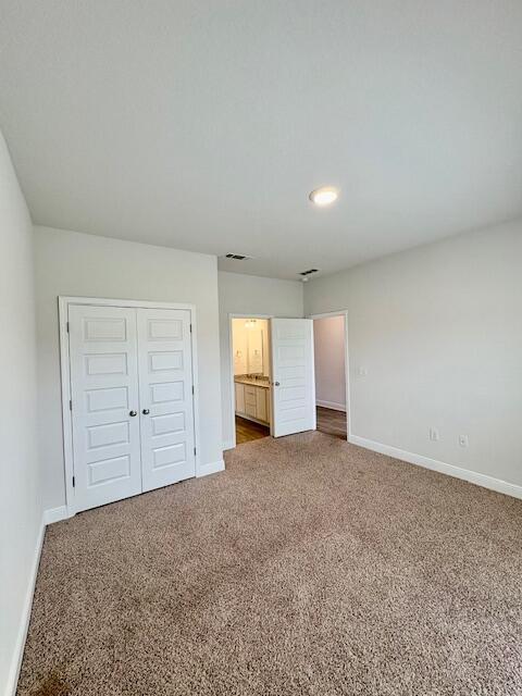8177 Majestic Cypress Dr, Milton, FL 32583 - unfurnished bedroom featuring carpet floors, baseboards, and a closet