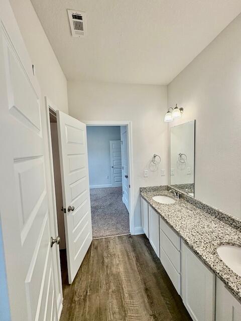 8177 Majestic Cypress Dr, Milton, FL 32583 - bathroom with double vanity, visible vents, wood finished floors, and a sink