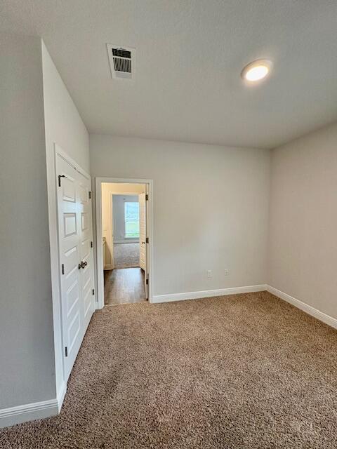 8177 Majestic Cypress Dr, Milton, FL 32583 - empty room with carpet, baseboards, and visible vents
