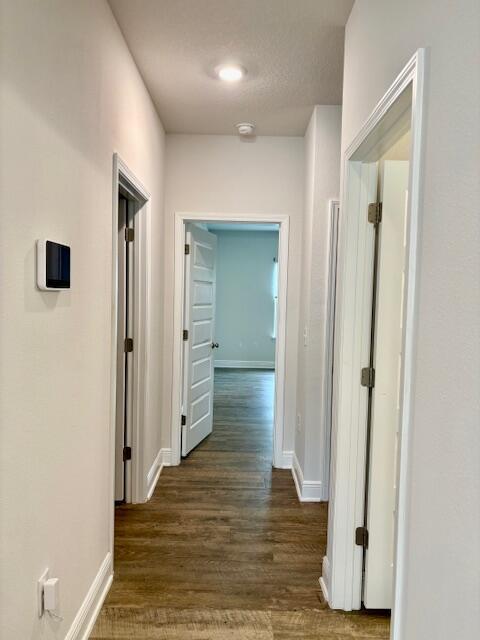8177 Majestic Cypress Dr, Milton, FL 32583 - hallway with dark wood-type flooring and baseboards