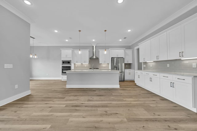 kitchen featuring appliances with stainless steel finishes, wall chimney exhaust hood, white cabinetry, and hanging light fixtures