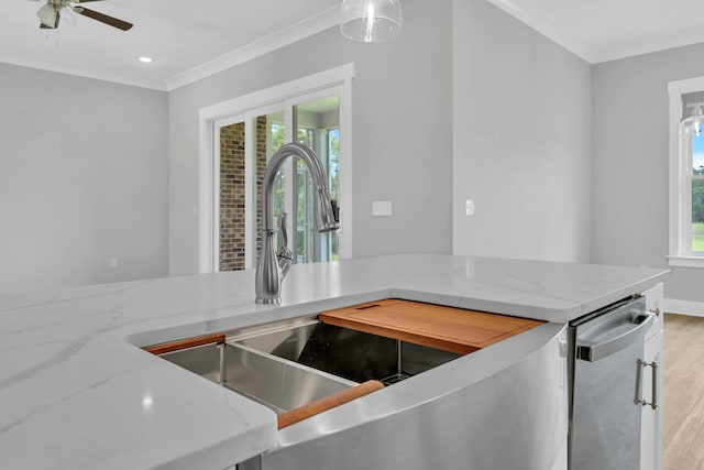 kitchen with light hardwood / wood-style floors, light stone counters, crown molding, and ceiling fan