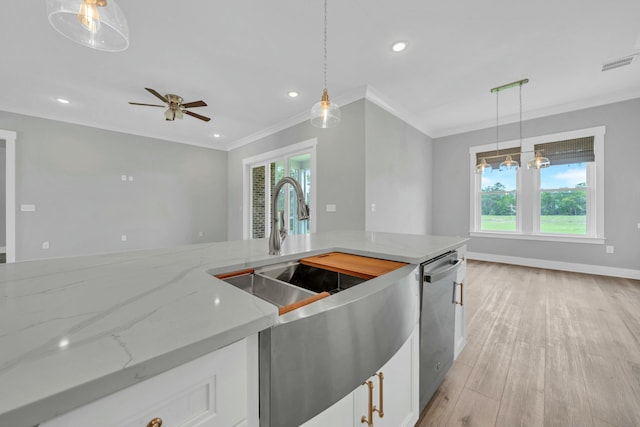 kitchen featuring crown molding, pendant lighting, and light stone counters