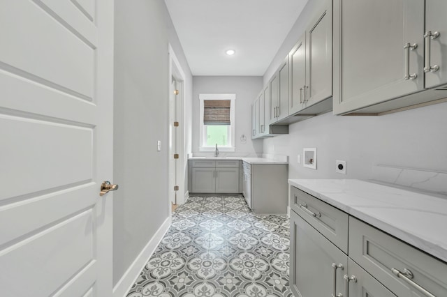 laundry room with sink, hookup for an electric dryer, hookup for a washing machine, and cabinets