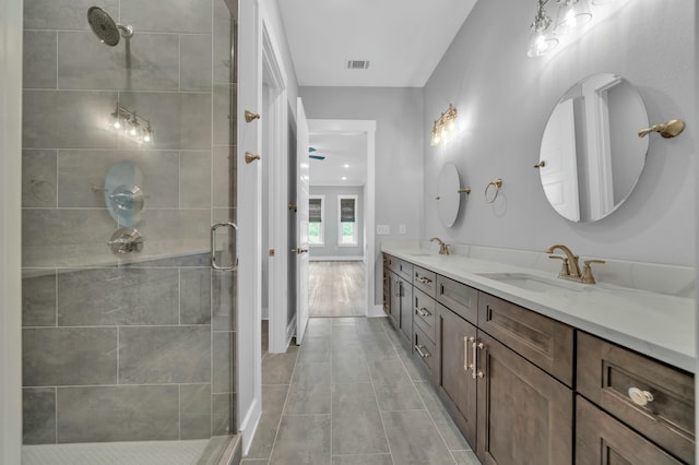 bathroom featuring a shower with door, tile patterned floors, and vanity