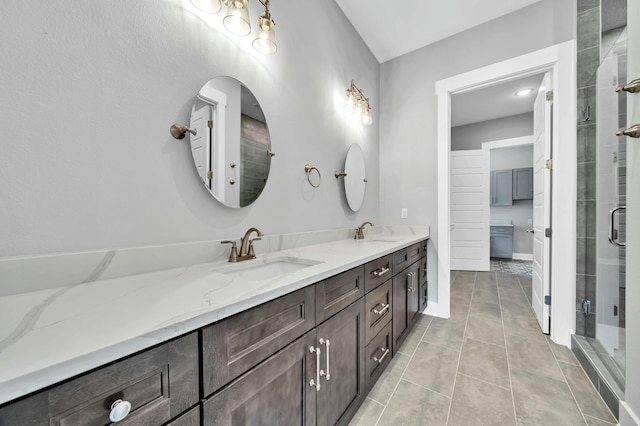 bathroom featuring a shower with shower door, vanity, and tile patterned flooring