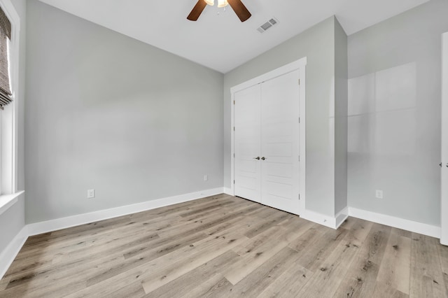 unfurnished bedroom featuring ceiling fan, a closet, and light hardwood / wood-style flooring