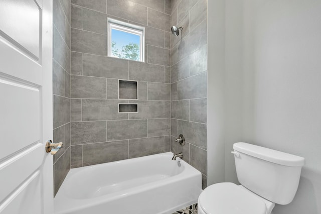 bathroom with toilet and tiled shower / bath