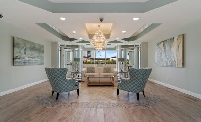 living area with crown molding, a raised ceiling, and a notable chandelier