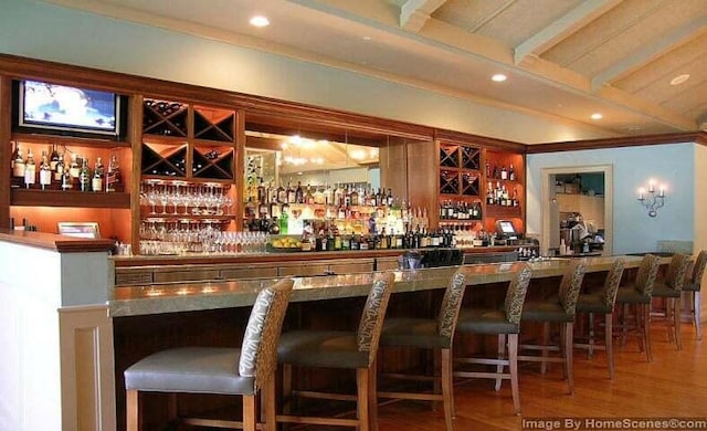 bar featuring beamed ceiling and hardwood / wood-style floors