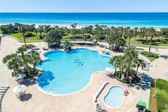 view of swimming pool featuring a water view and a patio