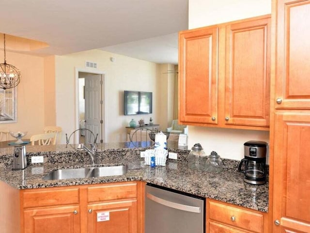 kitchen with kitchen peninsula, dishwasher, dark stone counters, hanging light fixtures, and sink