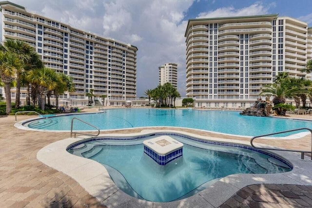 view of swimming pool with a hot tub and a patio