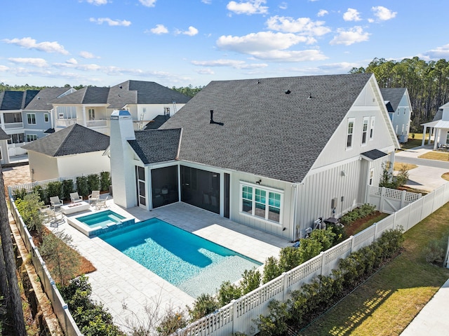 back of house featuring a pool with hot tub, a patio, and a sunroom