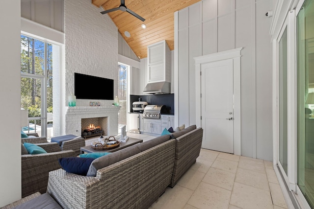 living room with wooden ceiling, ceiling fan, a fireplace, and high vaulted ceiling