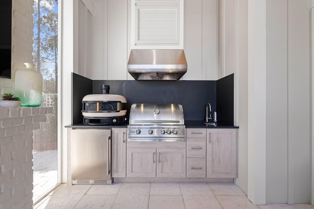 kitchen featuring backsplash, fridge, sink, and light brown cabinets