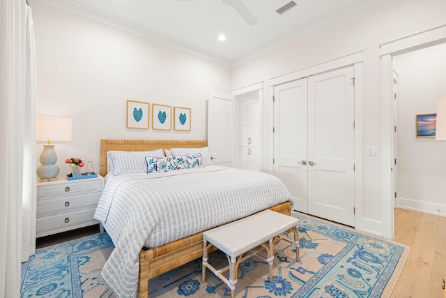 bedroom featuring ceiling fan, crown molding, and light hardwood / wood-style floors