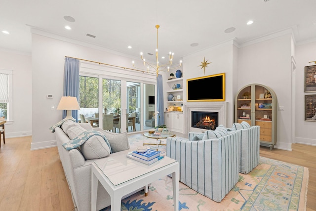 living room with light wood-type flooring, a chandelier, crown molding, and built in features