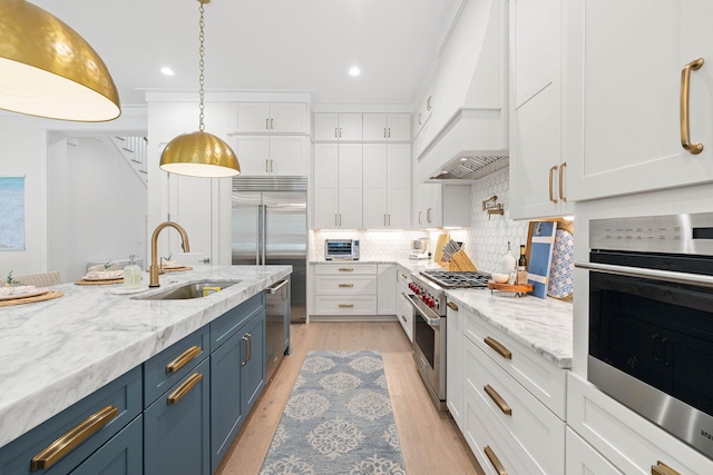 kitchen featuring decorative backsplash, blue cabinetry, premium appliances, and white cabinets