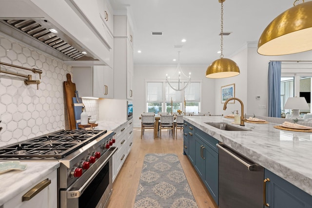 kitchen featuring tasteful backsplash, appliances with stainless steel finishes, blue cabinets, and premium range hood