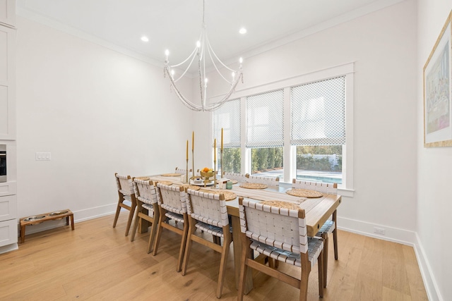 dining room with an inviting chandelier, ornamental molding, and light hardwood / wood-style flooring