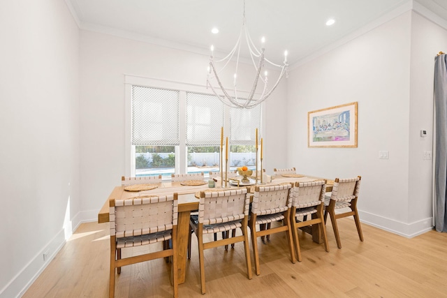 dining space with an inviting chandelier, ornamental molding, and light hardwood / wood-style floors