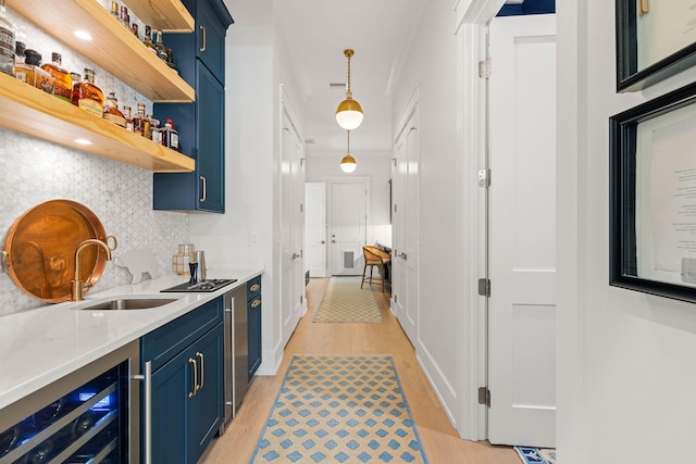 bar featuring backsplash, beverage cooler, blue cabinetry, and light hardwood / wood-style floors