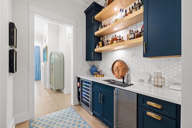 bar featuring backsplash, refrigerator, light hardwood / wood-style floors, blue cabinetry, and beverage cooler