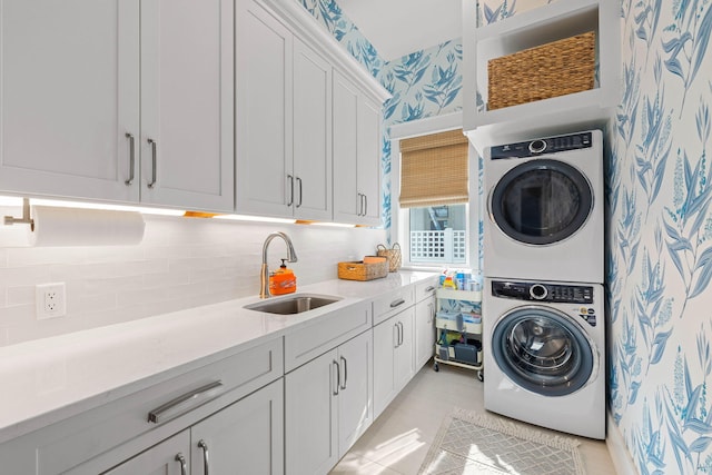 washroom with cabinets, sink, stacked washer and dryer, and light tile patterned flooring